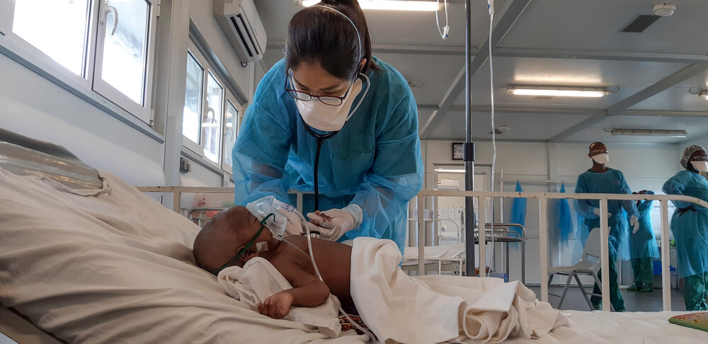 Dottoressa MSF con un piccolo paziente nell'unità di terapia intensiva dell'ospedale di Hangha, distretto di Kenema