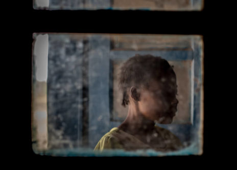 Donna attraverso il vetro di una finestra.