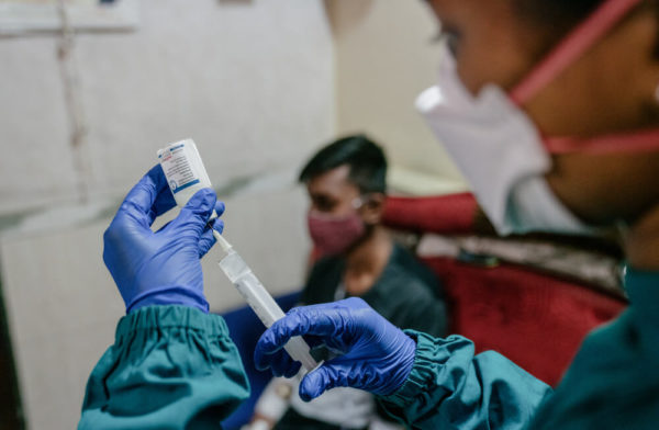 Un paziente affetto da tubercolosi resistente ai farmaci attende che l'infermiera prepari il farmaco per la tubercolosi per via endovenosa