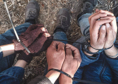 le mani ammanettate di tre persone, trovate così a Lesbo