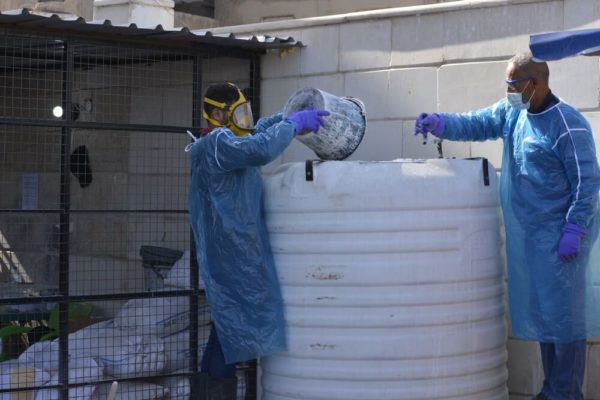Una squadra di operatori idrici e sanitari mescola la calce con i fanghi fecali del centro di trattamento del colera per eliminare il Vibrio cholera, a Raqqa.