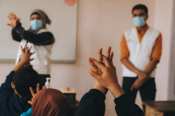 Un'operatrice sanitaria di MSF spiega ai bambini a scuola l'importanza di lavarsi le mani con il sapone per evitare di contrarre il colera.