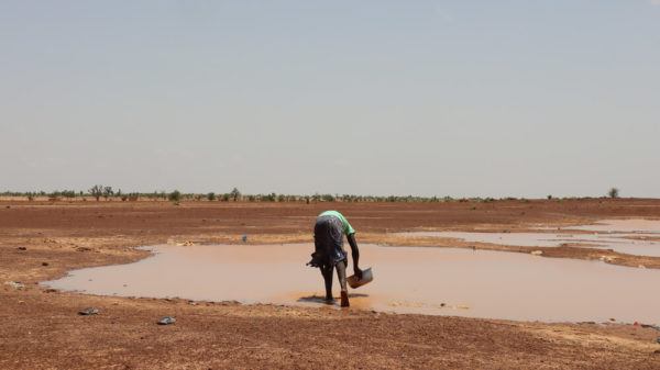 Uomo prende l'acqua da una pozza in Burkina Faso Malaria e Malattie trasmissibili via acqua