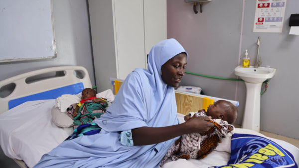 Infermiera MSF si prende cura di due gemelli colpiti dalla malnutrizione a Maiduguri, Borno State